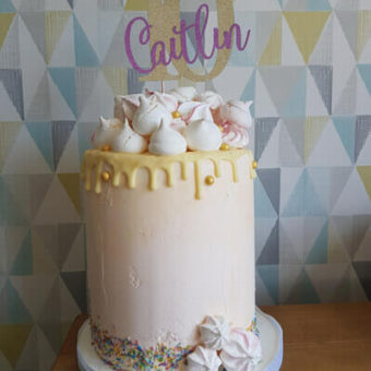 Tall pale peach buttercream and white chocolate drip 10th birthday cake decorated with meringues for Caitlin