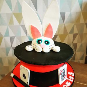 White, black and red top hat and rabbit magic cake with cards and wand