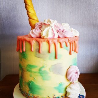 Tall yellow and green buttercream with orange drip unicorn birthday cake for Brooke
