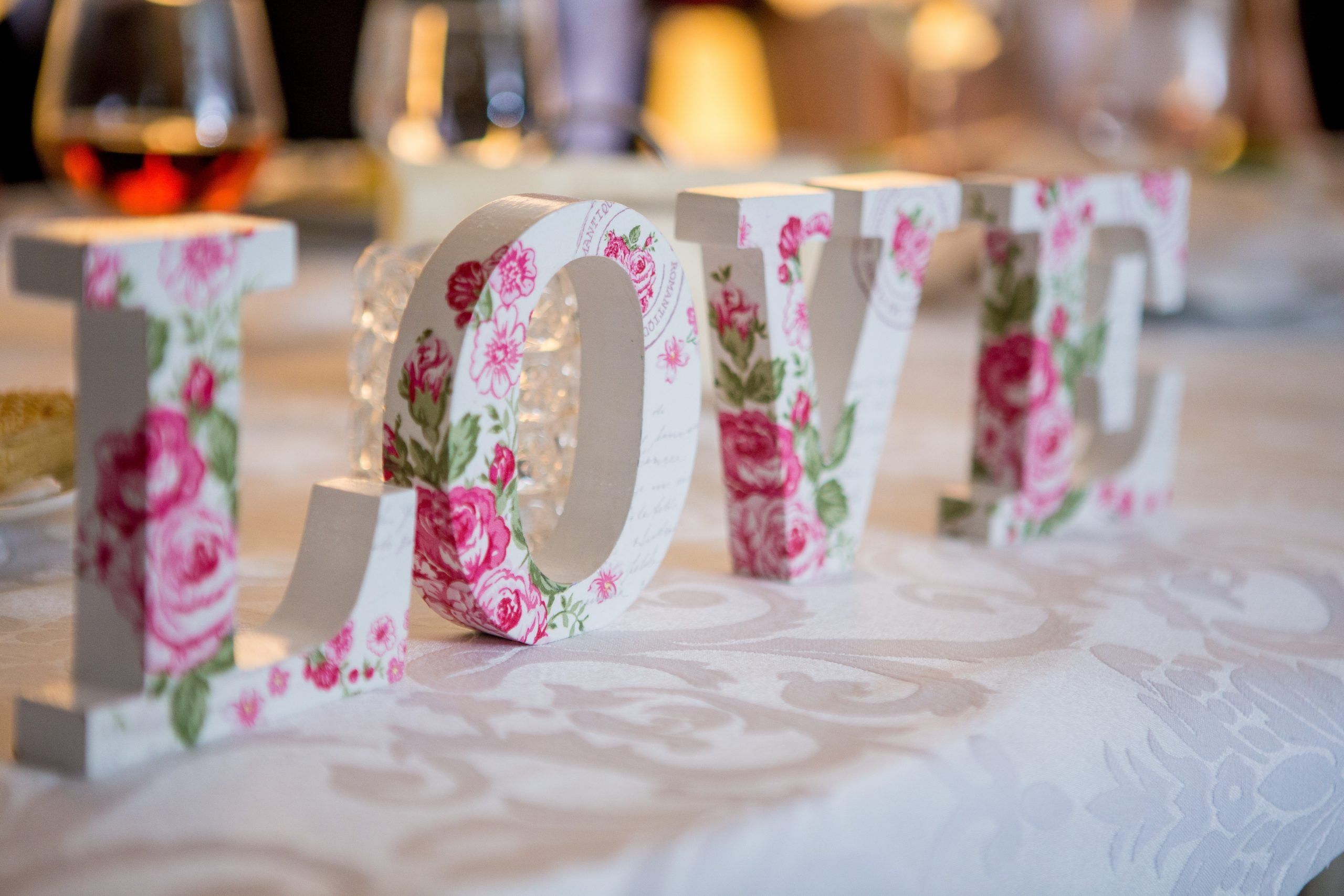 White and pick flowered wooden letters spelling LOVE