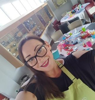Selfie of Charlotte setting up corporate event with tables and crafts in the background