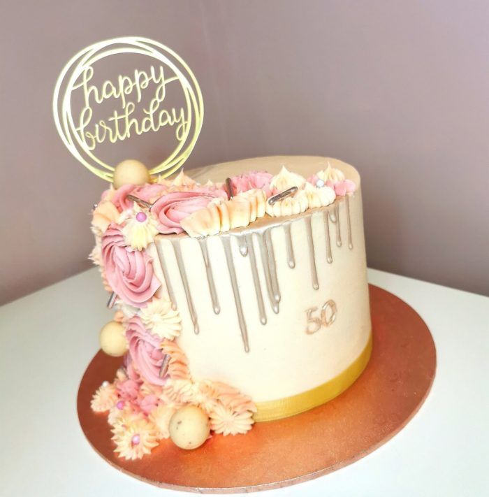 Cream and pink with silver drip 50th birthday cake decorated with iced flowers