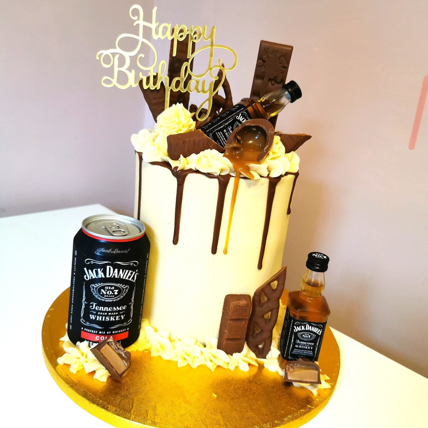 Tall cream and brown buttercream Jack Daniel's and chocolate themed birthday cake