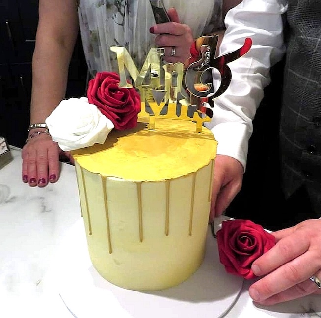 Tall buttercream cream wedding cake with gold drip, Mr & Mrs topper and white and red roses