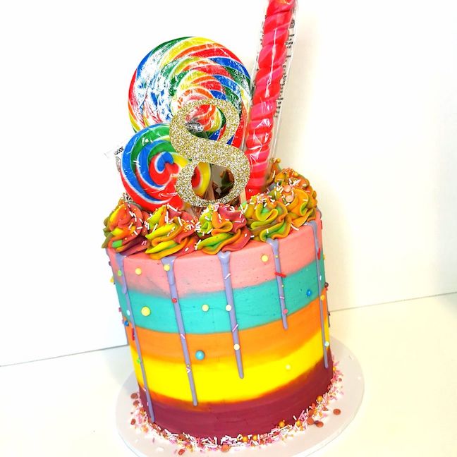 Tall rainbow themed buttercream 8th birthday cake