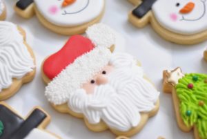 Decorated Christmas biscuits including santa, snowman and tree on white background