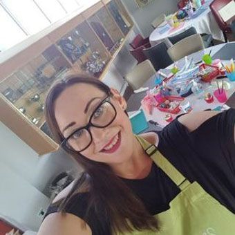 Selfie of Charlotte setting up corporate event with tables and crafts in the background