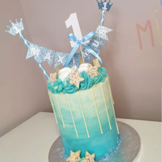 Tall cream and blue buttercream drip 1st birthday cake for "Maximus" decorated with white chocolate sprinkle stars