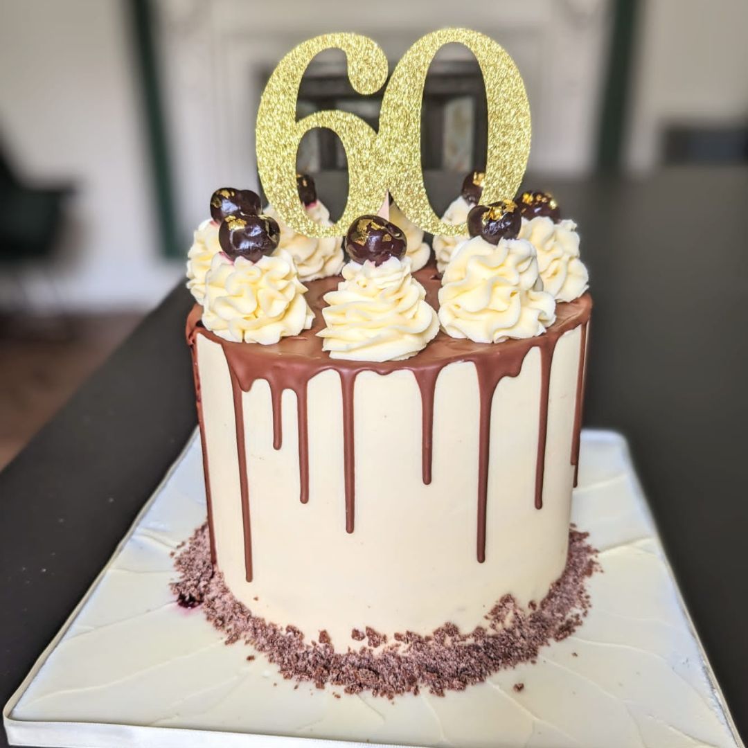 Tall chocolate drip buttercream 18th birthday cake decorated with assorted chocolate and a black "18 Corbin" drum kit topper