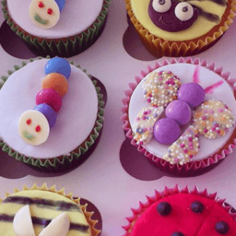 Close up of insect themed decorated cupcakes - bees, caterpillars, butterflies, ladybirds
